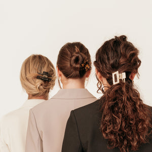 Drie modellen met stijl en krullend haar met verschillende stevige klemmen in het haar.