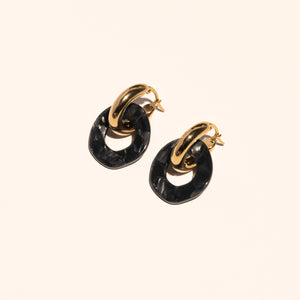 Gouden ringen met een kleine ronde hanger van acetaat in de kleur Midnight Pearl.